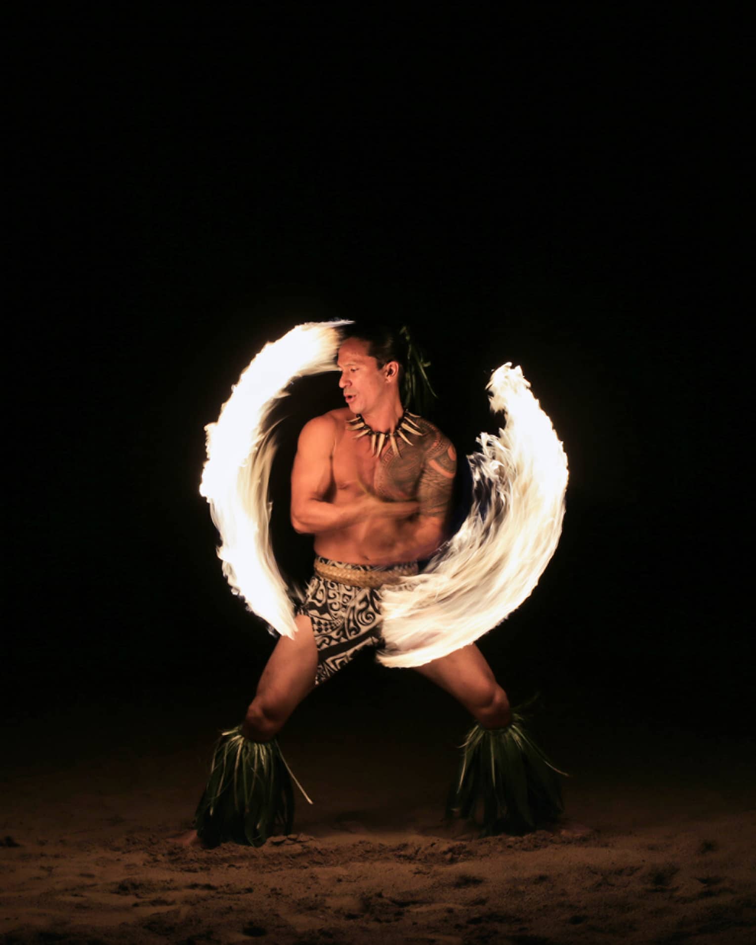 Fire dancer spins fire on the beach