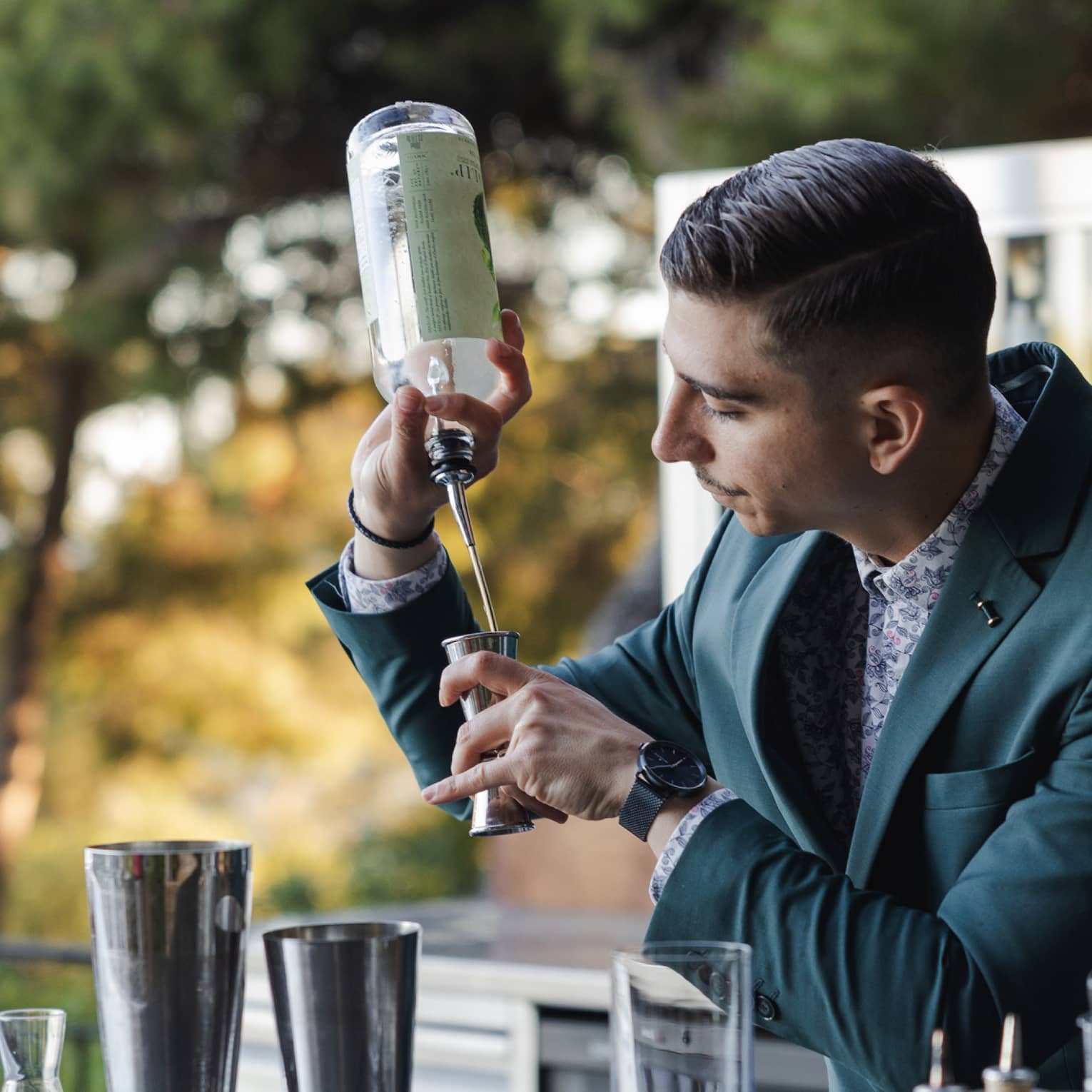A bartender making a cocktail at an outdoor bar
