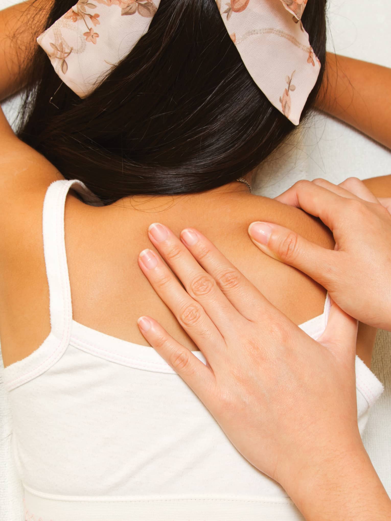 Masseuse hands massage girl's shoulders