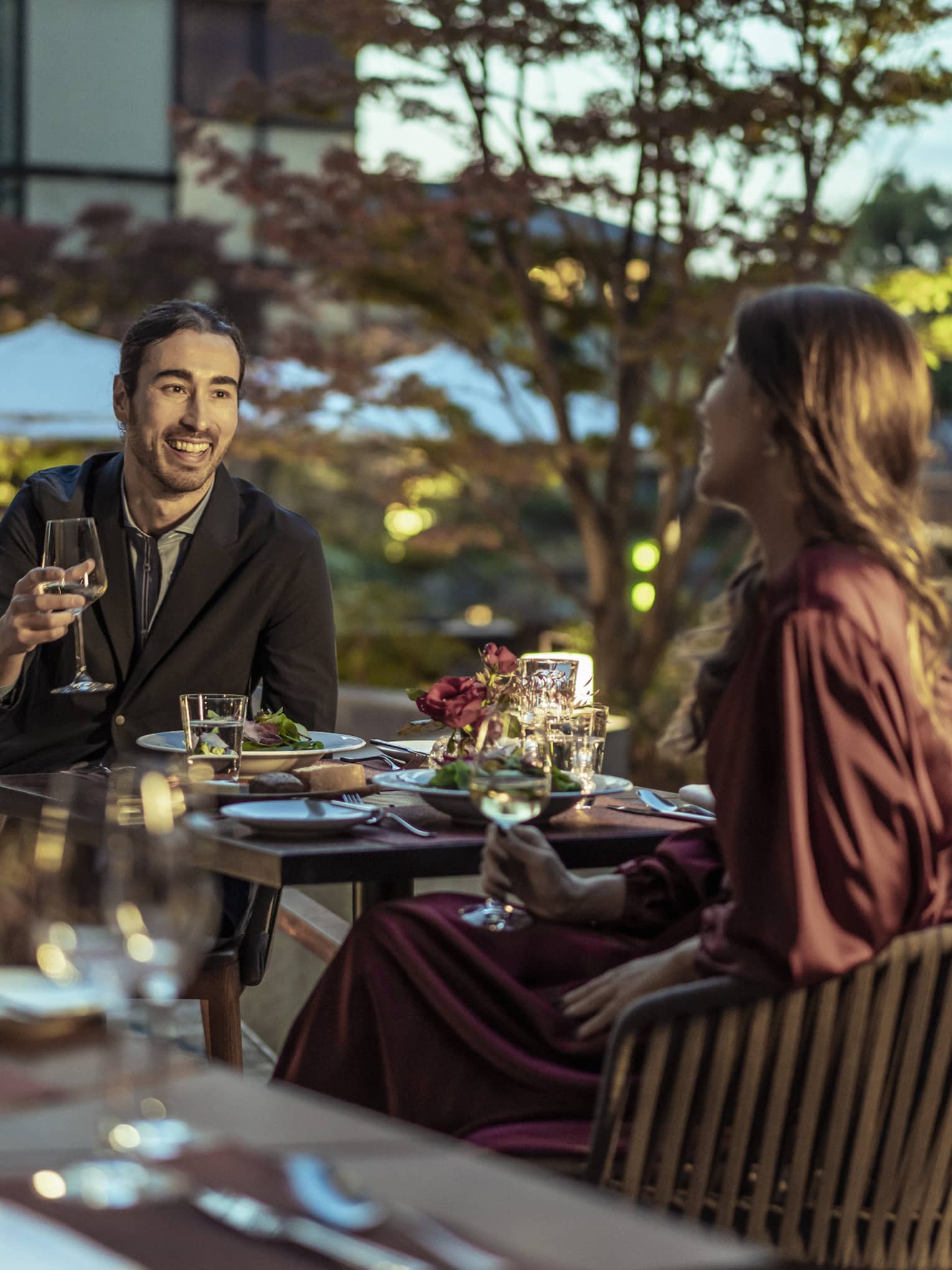 Couple enjoys a romantic meal at dusk on Brasserie?s outdoor terrace with views of Shakusui-en pond garden