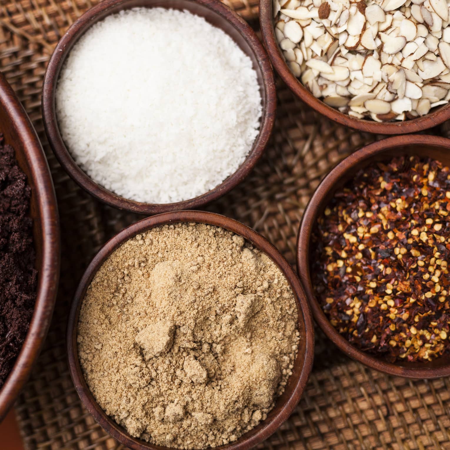 Small bowls of ground roasted cocoa beans, sugar, red chiles