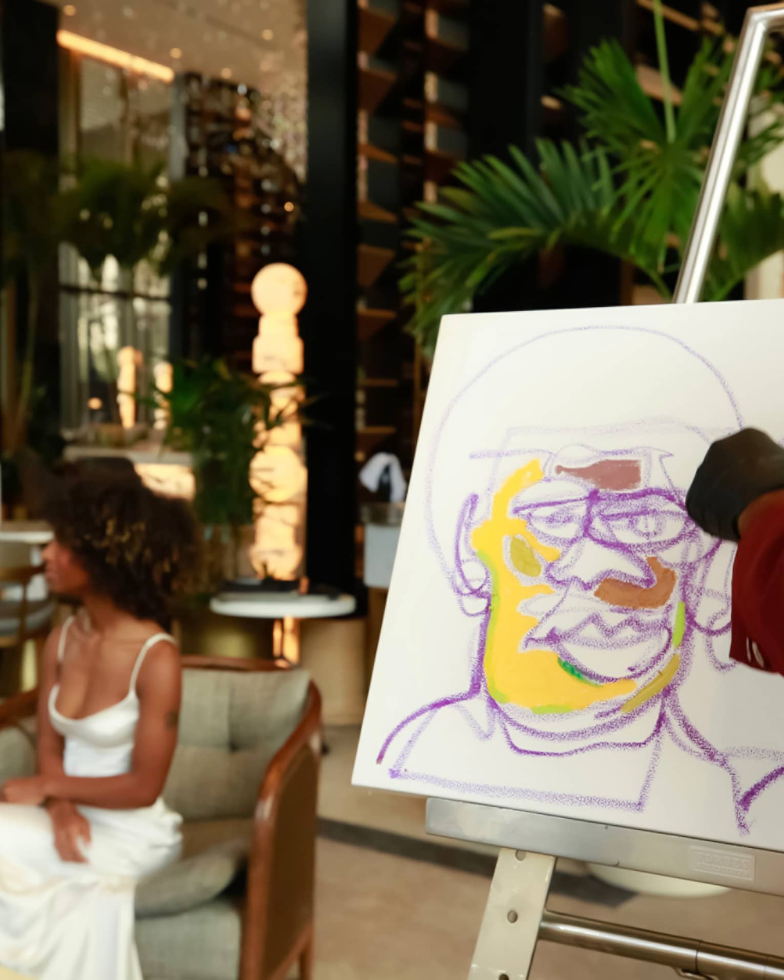 Two people enjoying wine while having a colourful portrait drawn of them.