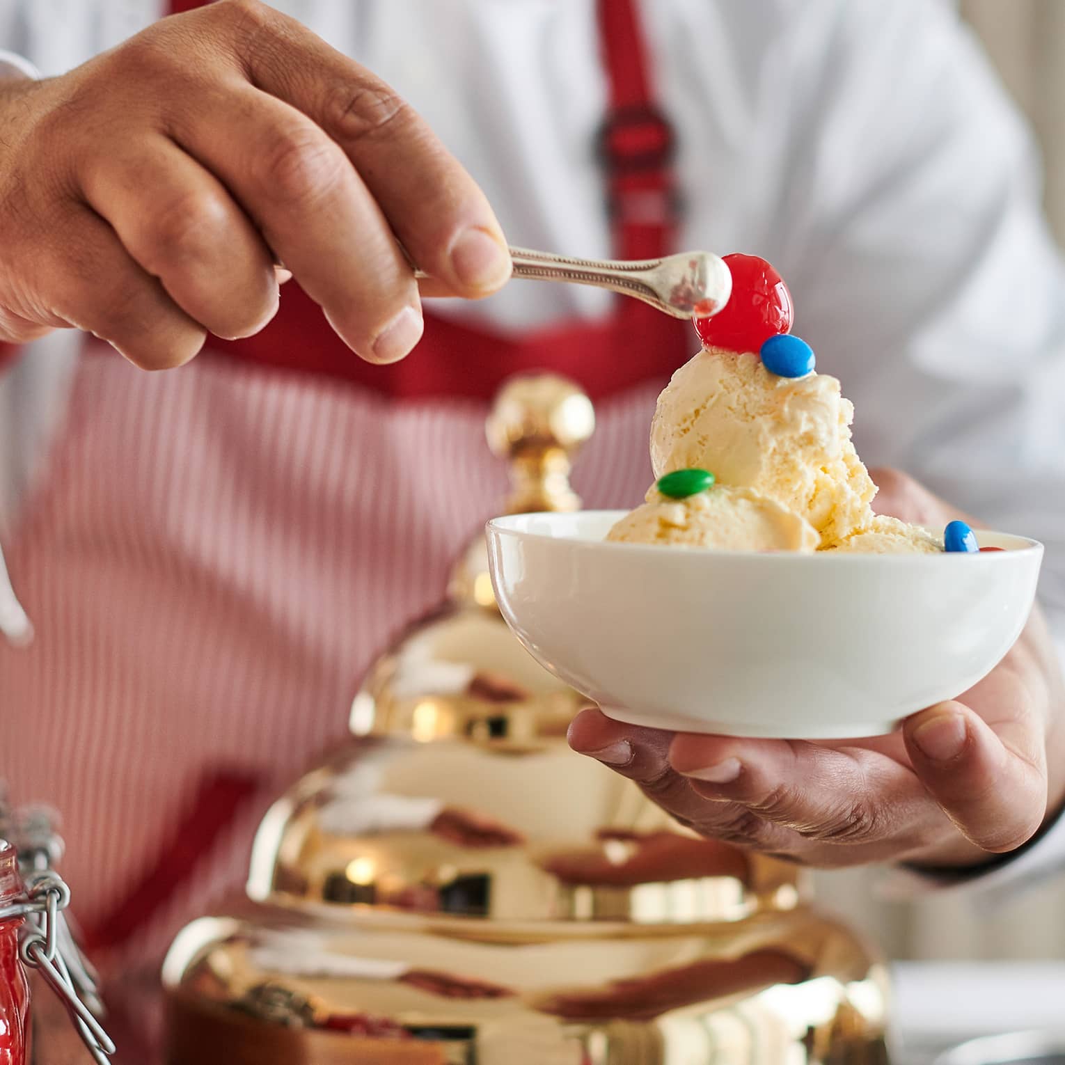 Man making an ice cream sundae from a retro Ice Cream Cart