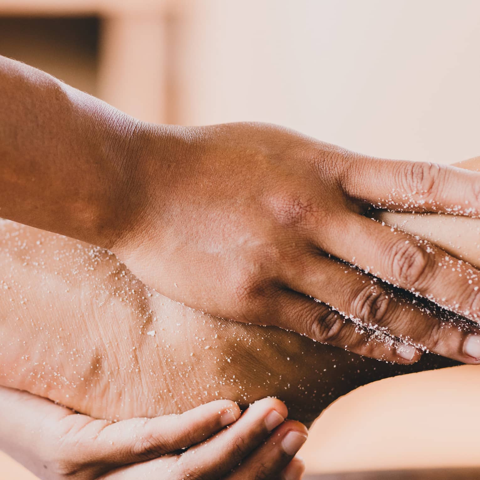 Hands hold a person's foot and ankle in a spa