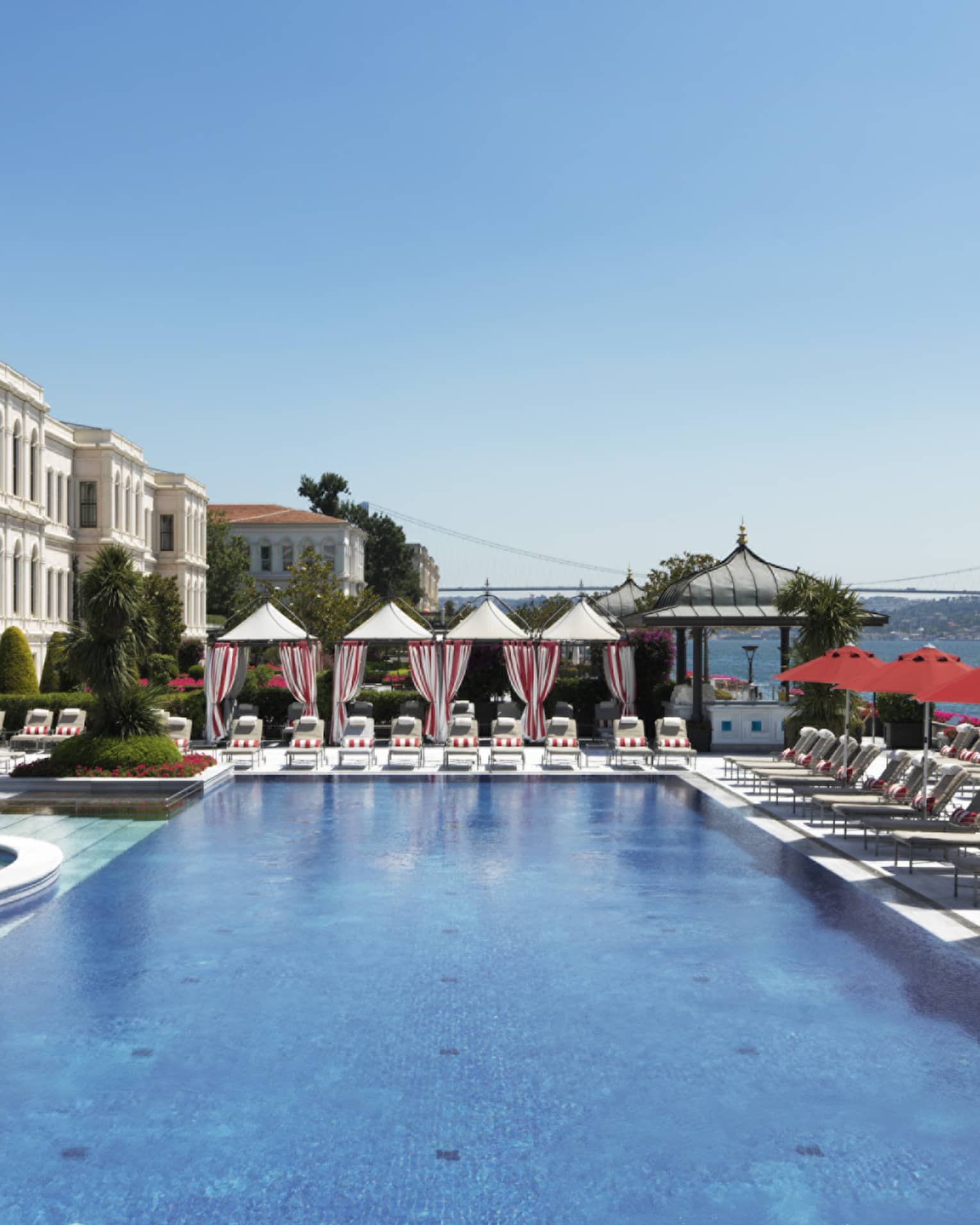 The Club large outdoor pool, sunny deck with rows of lounge chairs