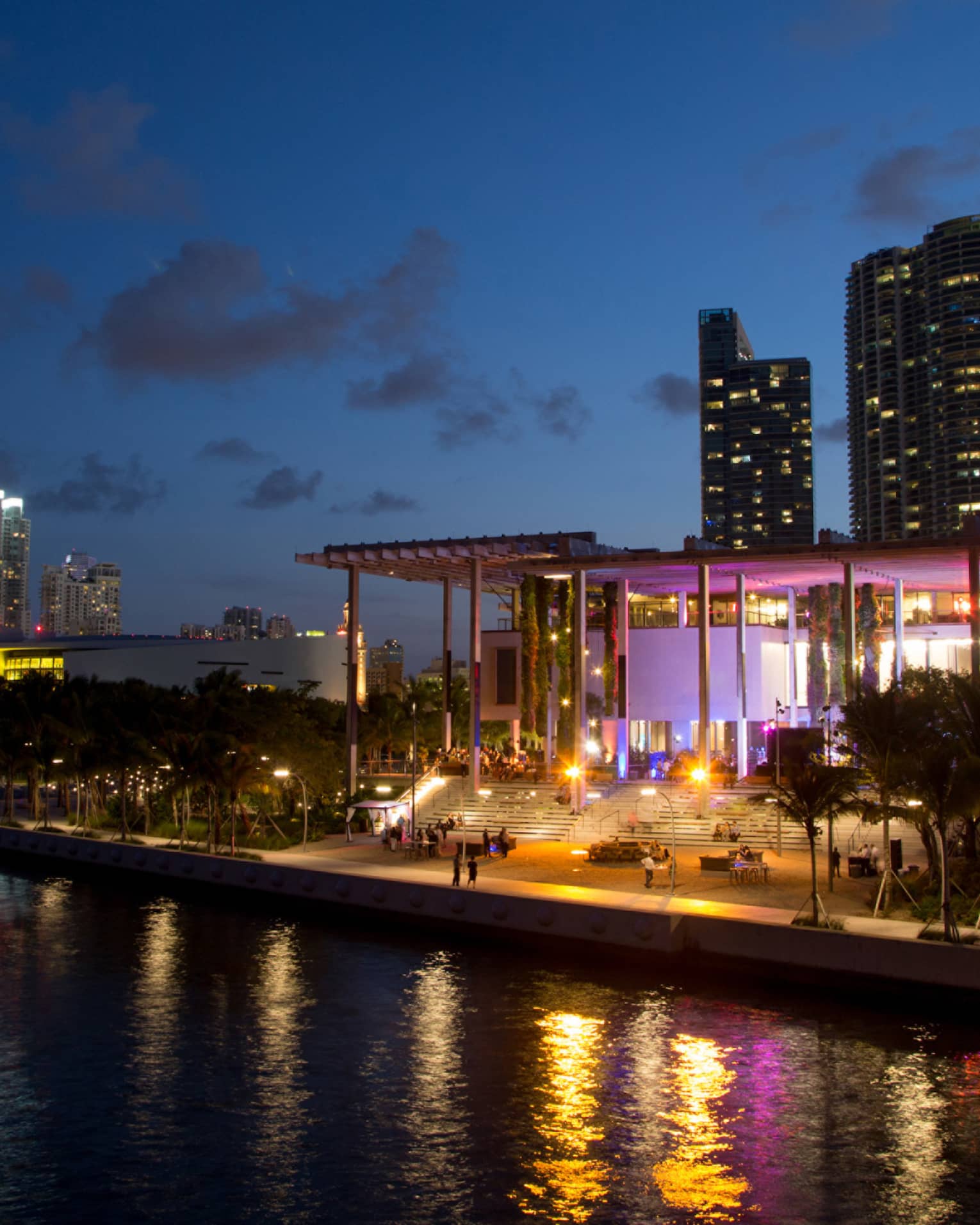Building with colourful lights at night along water 
