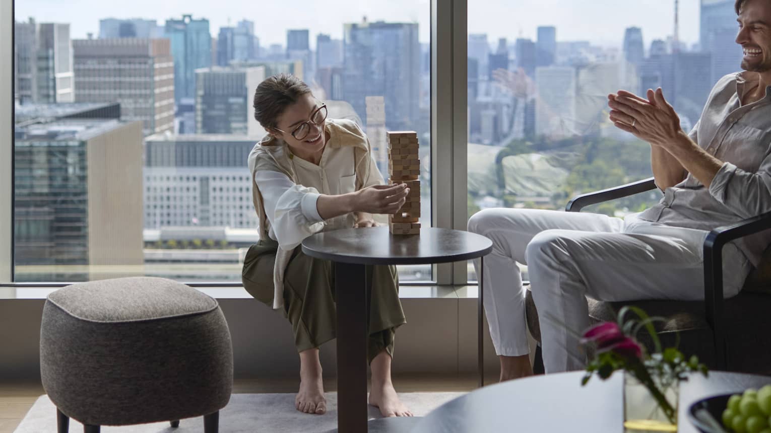 Couple enjoying a relaxing moment in a luxury suite at Four Seasons Hotel Tokyo at Otemachi with city views.