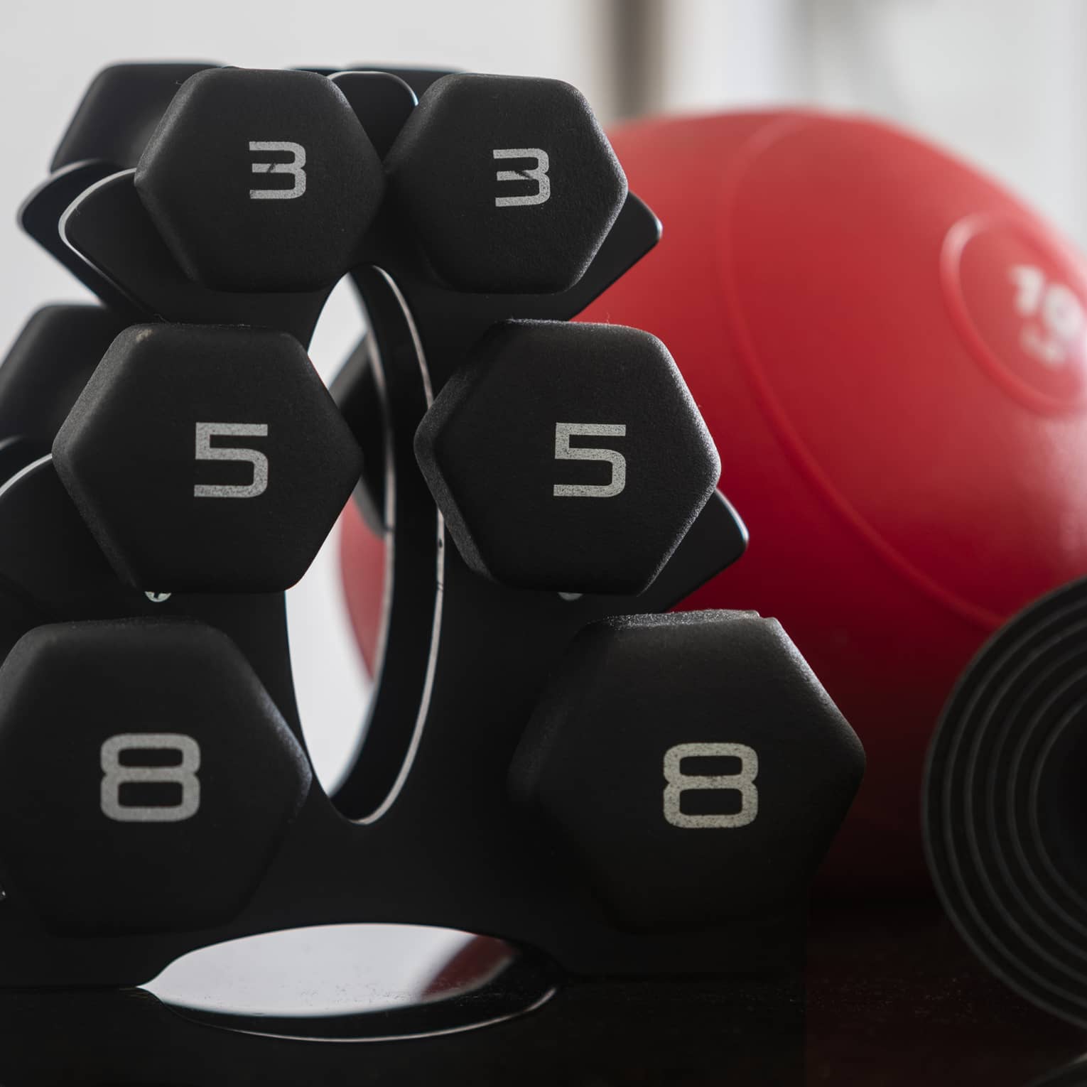 A set of free weights and a red weight ball.