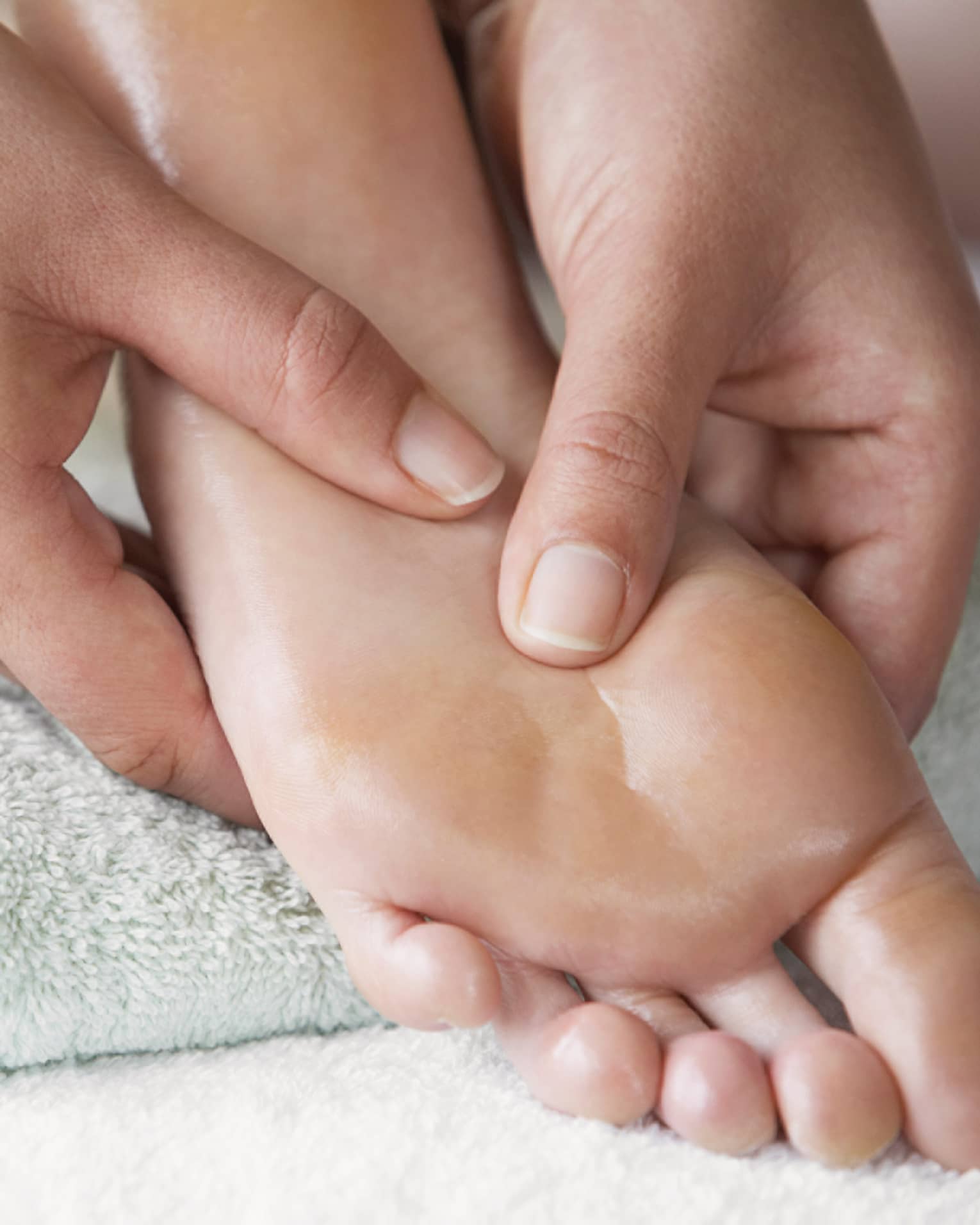 Close-up of hands massaging pressure points on feet