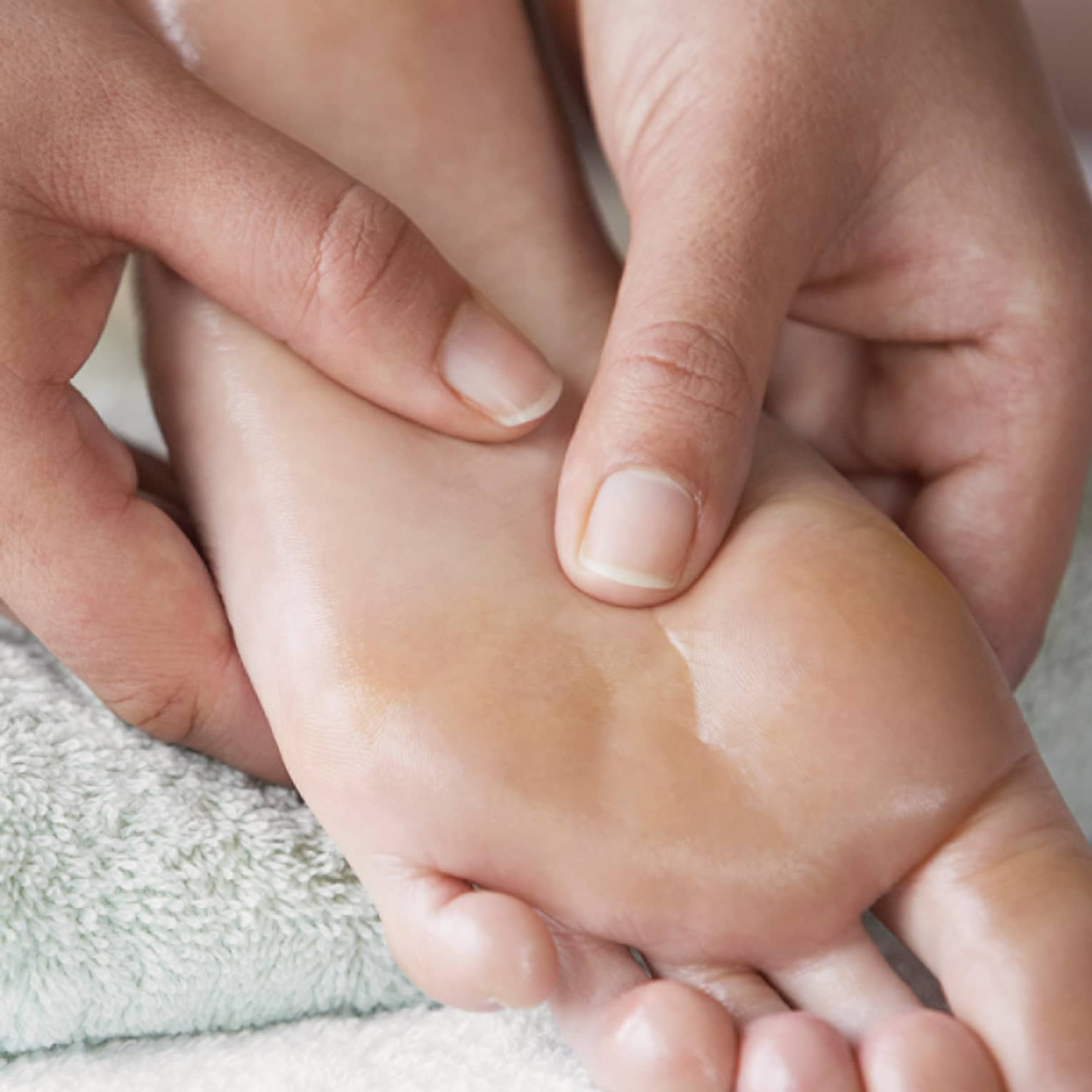 Close-up of hands massaging pressure points on feet