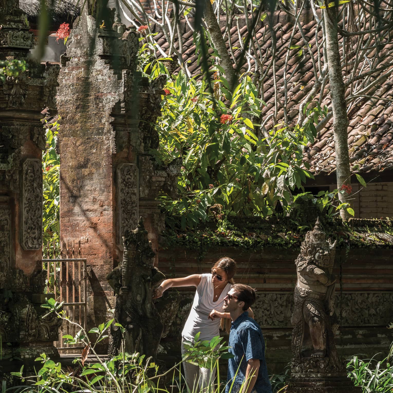 Gusts exploring decorative statues surrounding a temple in Bali