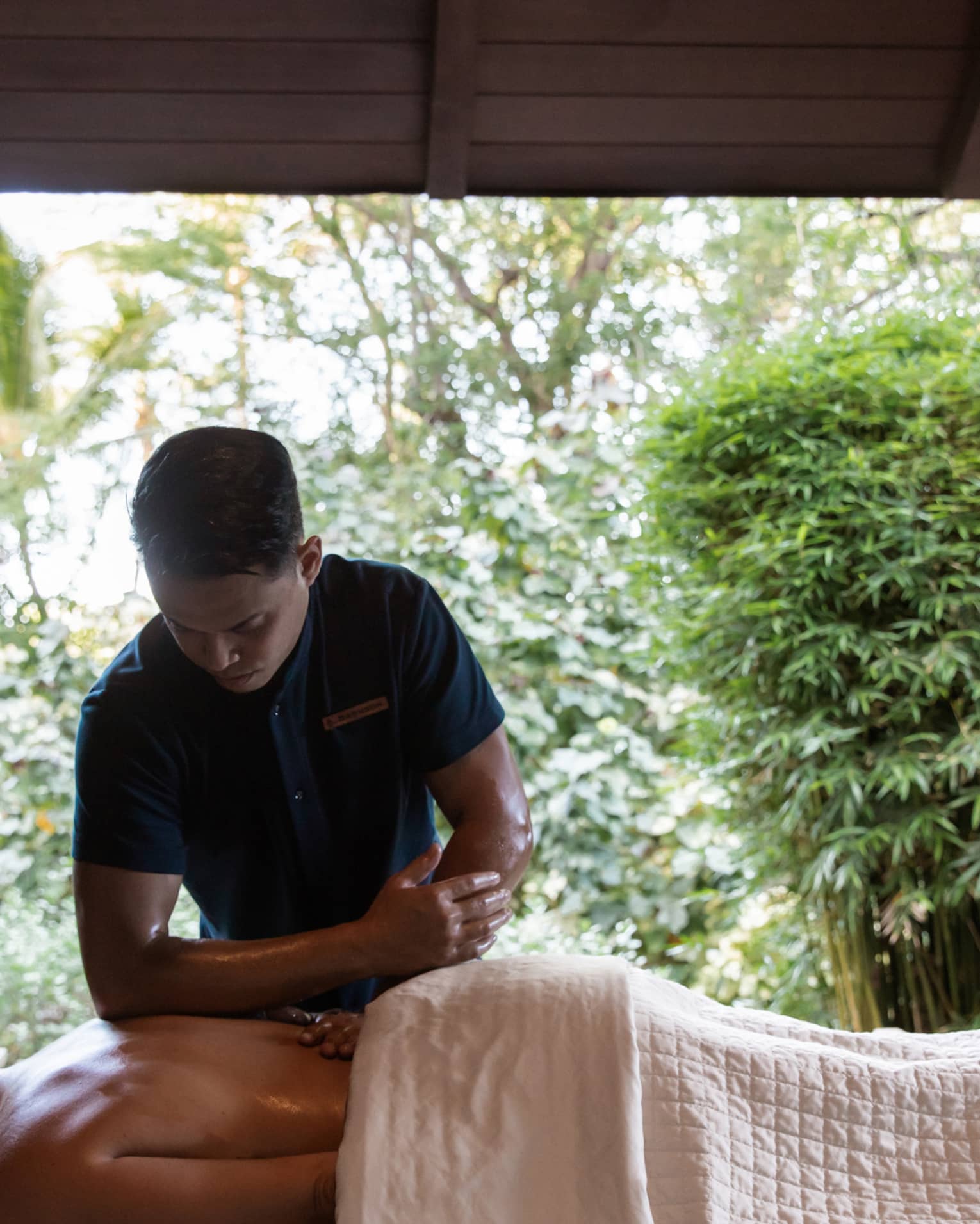 Man performs massage with elbow on back