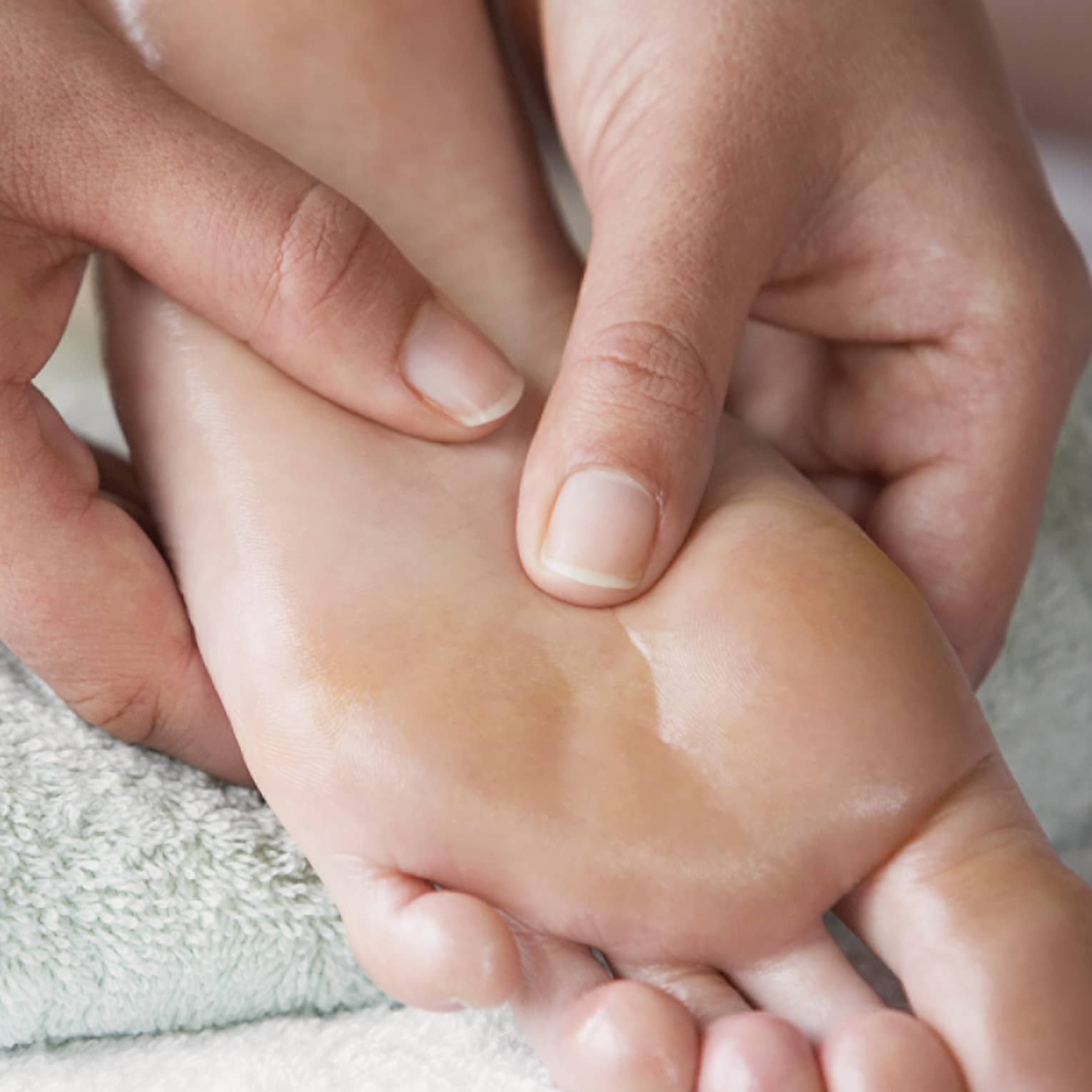 Close-up of hands massaging pressure points on feet
