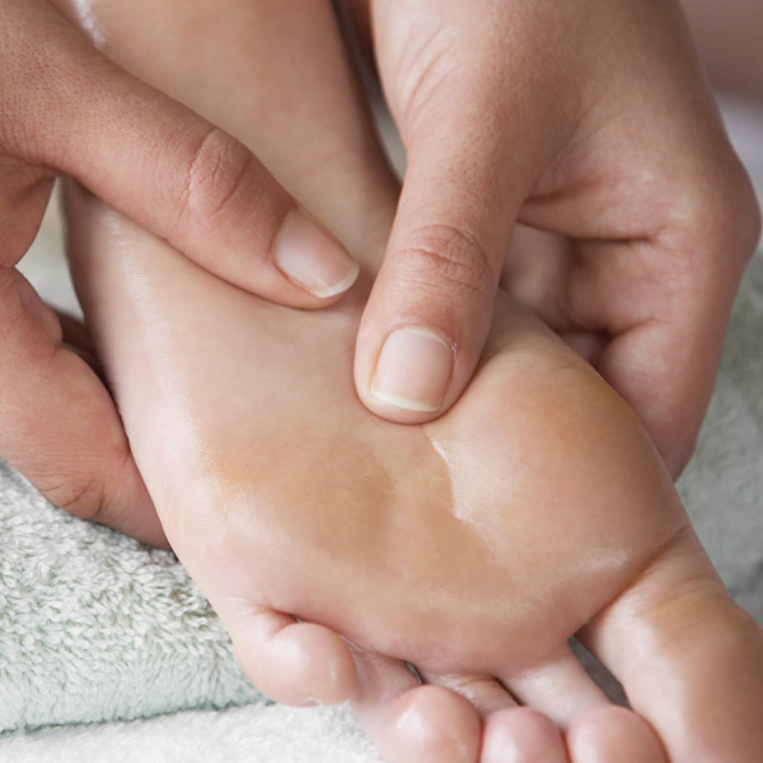 Close-up of hands massaging pressure points on feet