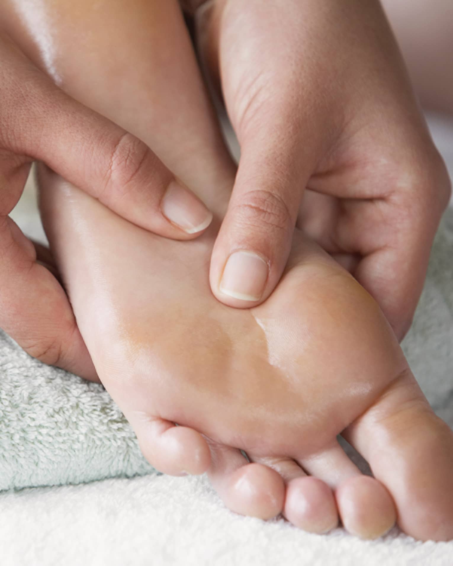 Close-up of hands massaging pressure points on feet