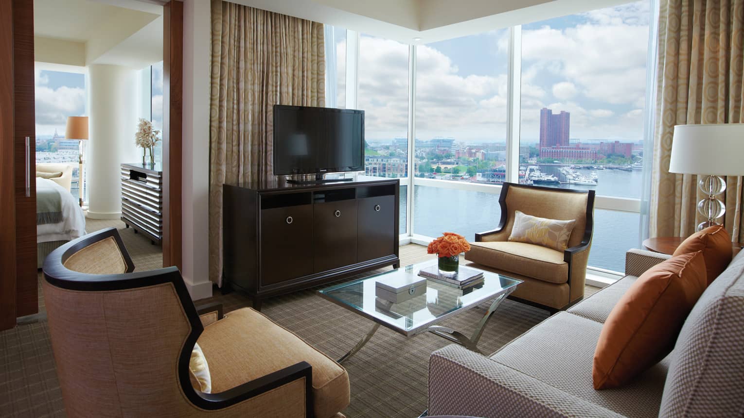 Spacious executive suite with city skyline views, comfortable seating and a large window.