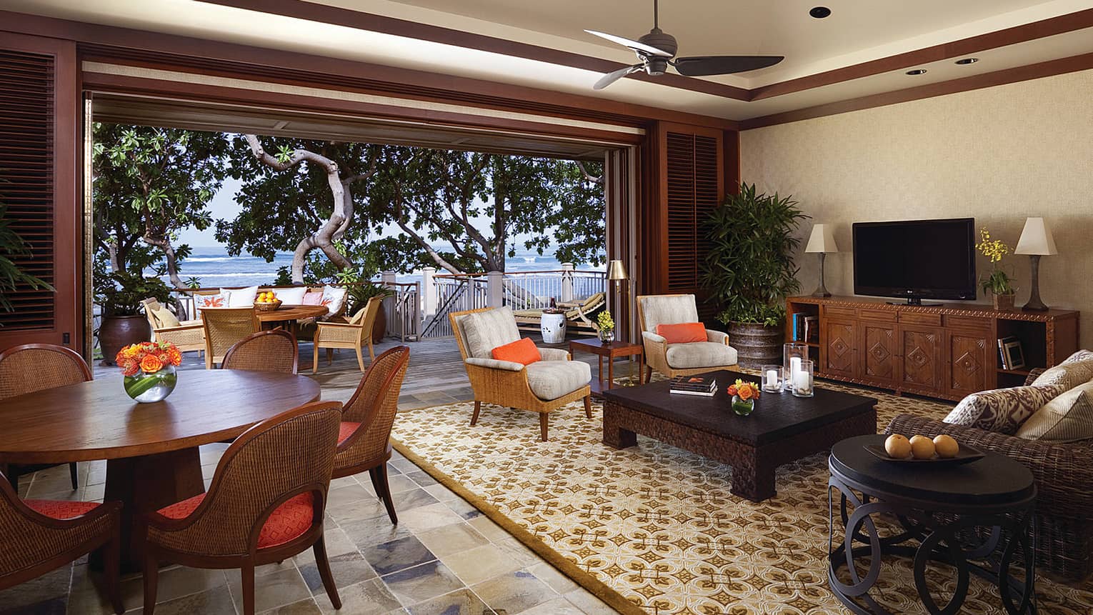 Kou Suite round dining table with modern wicker chairs, seating area by open wall