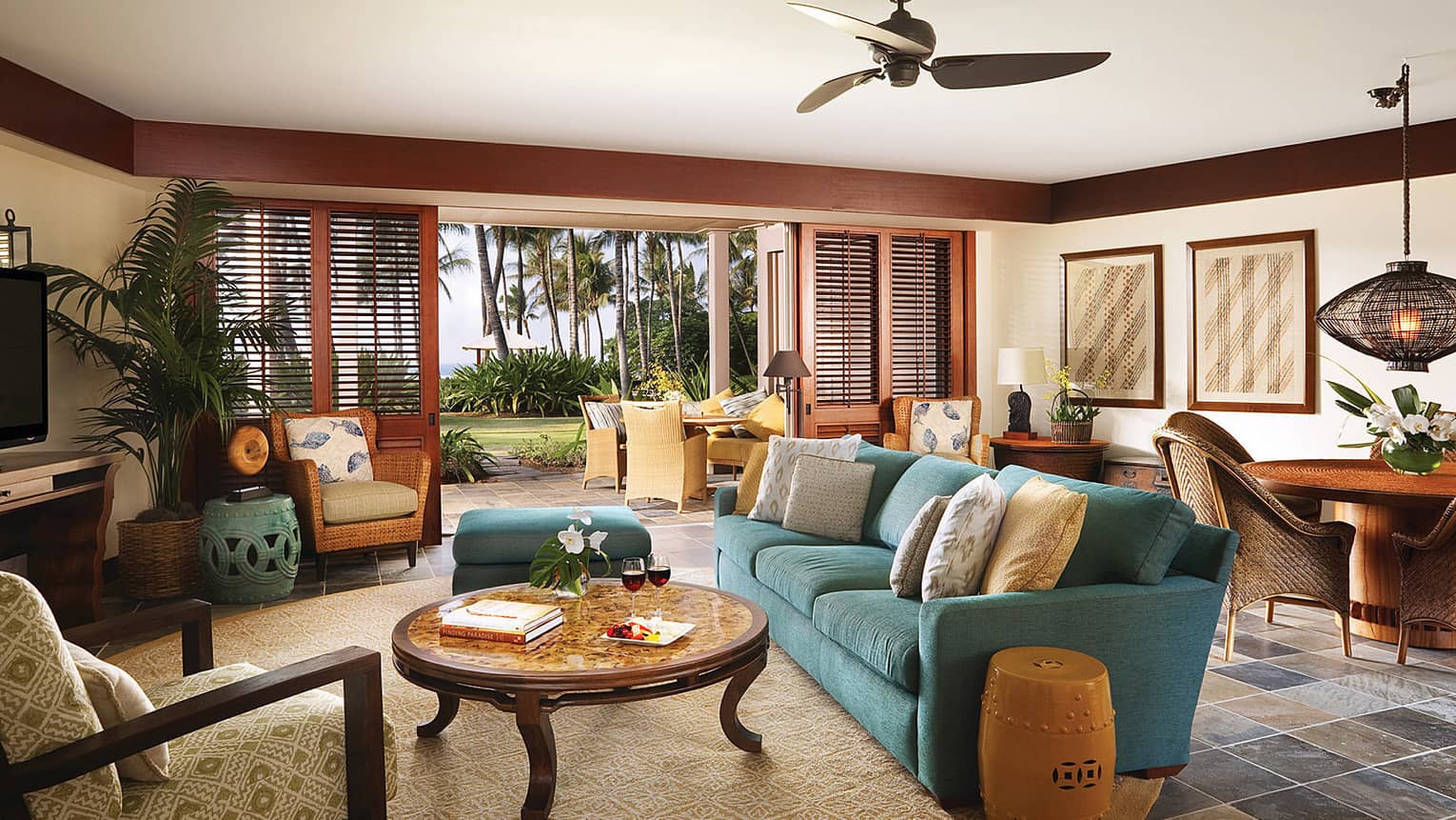Wai'olu Suite seating area on round area rug, table by open wood patio shutters