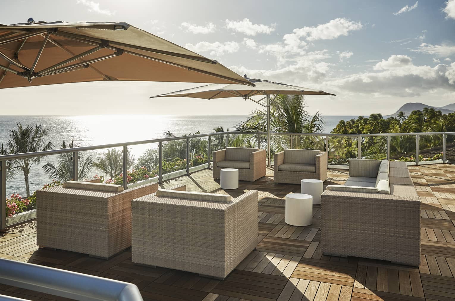 Presidential Suite patio with large wicker chairs, parquet floors, umbrellas, ocean view