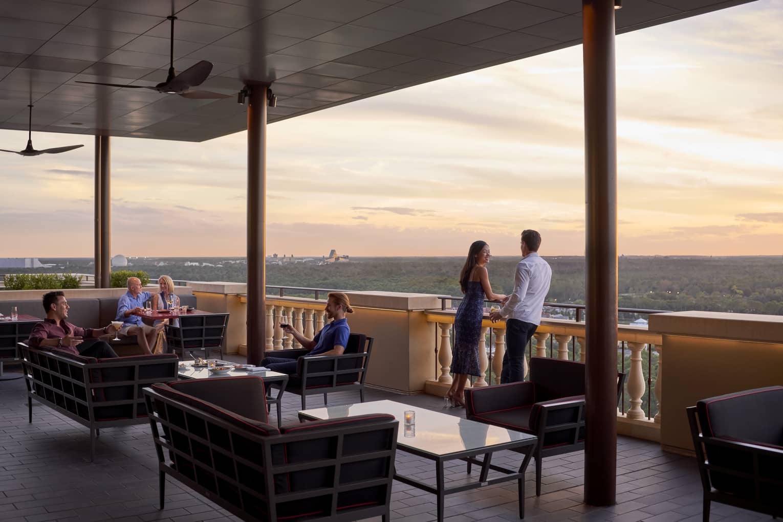 People lounge on Capa Bar terrace under roof at sunset