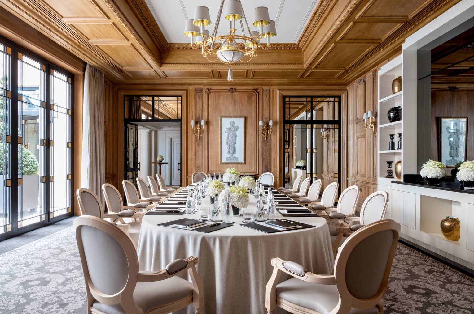 Long dining table, chairs in bright Napoléon meeting room with large windows