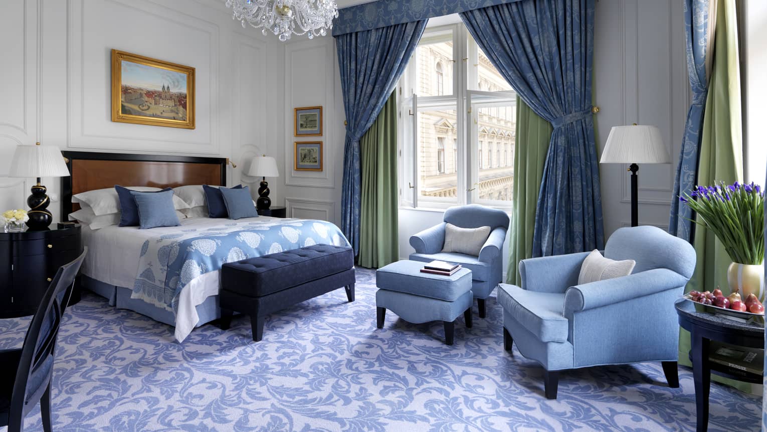 Renaissance Room with powder-blue decor, plush armchairs and footstool beside bed, blue-and-white carpet