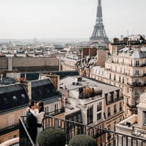 Couple embracing on Paris Hotel terrace with Eiffel Tower view