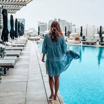 Back of woman walking across outdoor swimming pool deck