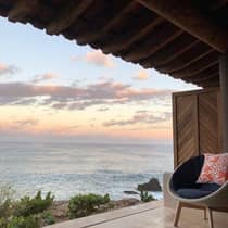 Oceanfront view from an outdoor terrace at Four Seasons Resort, featuring a comfortable chair