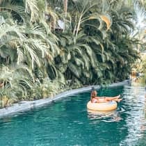 Captivating poolside moment at Four Seasons Resort Punta Mita, with a guest relaxing by the sparkling blue water under clear skies