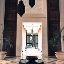 Modern black sculptures hang from white hotel lobby, hallway