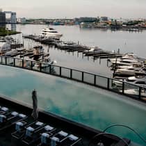 An outdoor pool deck overlooking a harbor view filled with boats