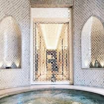 Decorative white screen around small round spa whirlpool