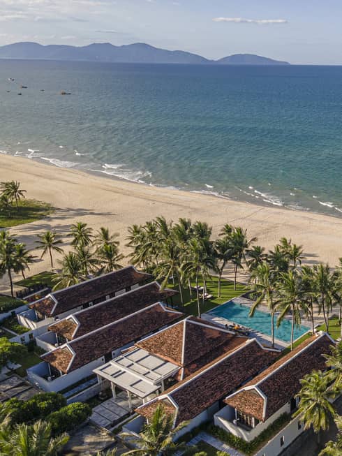 5 Bedroom Beachfront Pool Villa aerial shot with ocean and mountain views, palm trees and blue skies