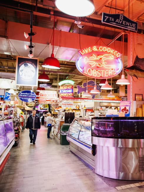 A large indoor market featuring fresh seafood behind glass windows.