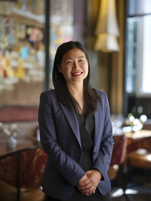 A woman in a blazer standing in a restaurant.