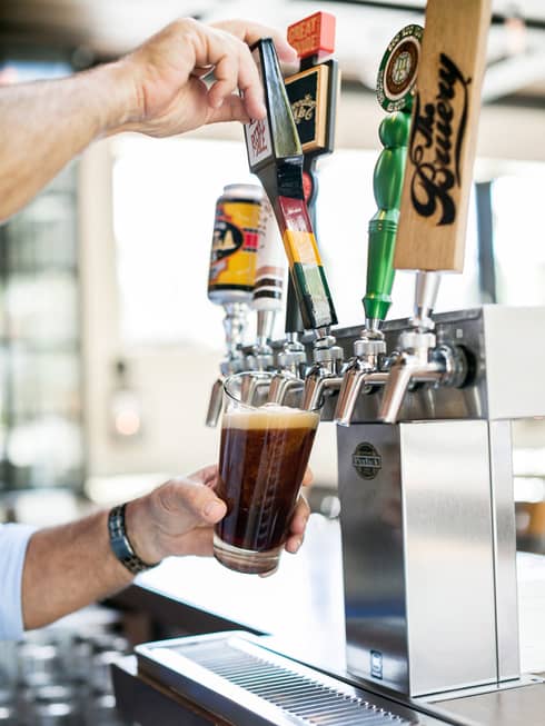 A draft beer being poured into a glass.