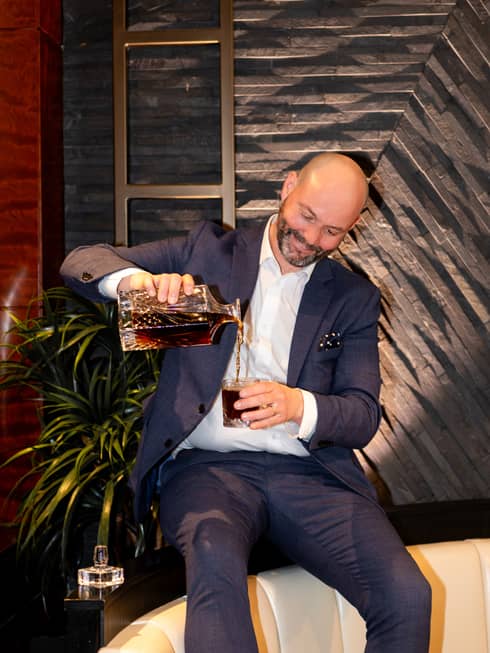 Craig Dryhurst pouring a drink into a glass.