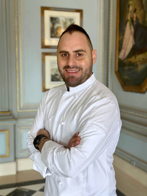 Chef Michele Fortunato in white chef's coat, smiling with arms crossed