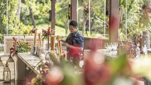 Bartender mixes drink at outdoor bar