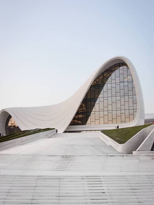 Concrete path leading up to Heydar Aliyev Center concrete building with arced shape