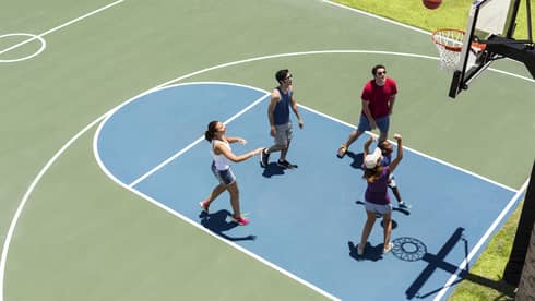 Aerial view of group of friends on basketball court, throwing ball in net