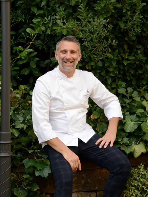 Portrait of Chef Paolo Lavezzini in front of greenery