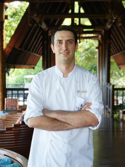 A portrait of Chef Fabian, crossing his arms over his chef shirt