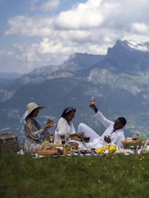 Three people enjoy gourmet picnic with ros� in French Alps