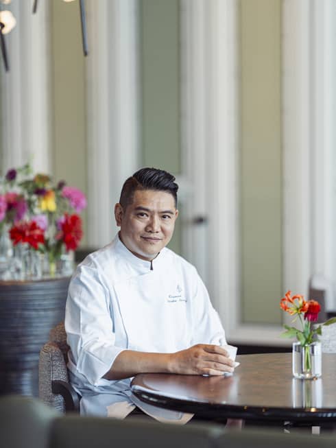 Chef Raymond Wong Wai Man sits at a dining table