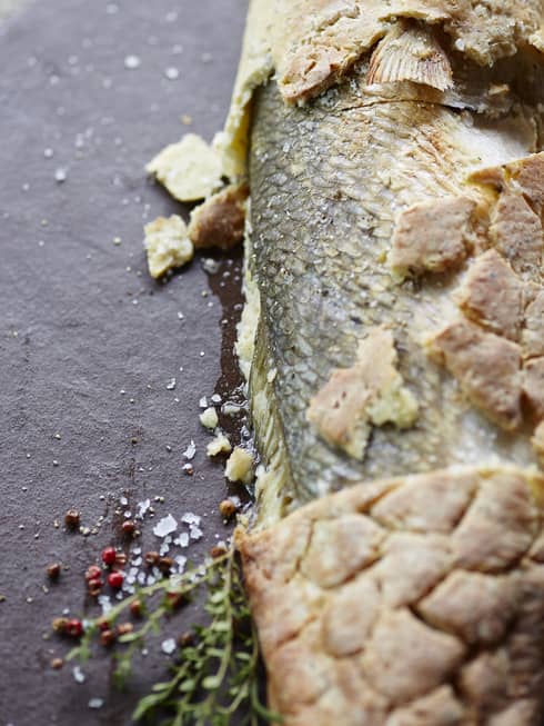 Salt-crusted fish garnished thyme