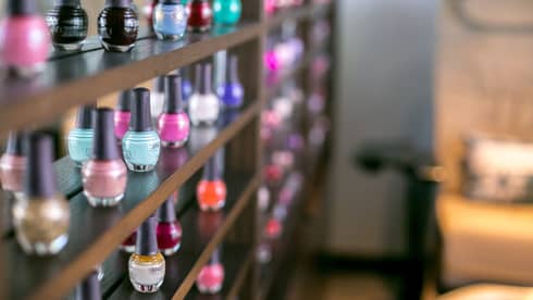 Close-up of colourful eco-friendly nail polish bottles on shelf at Driftwood Spa