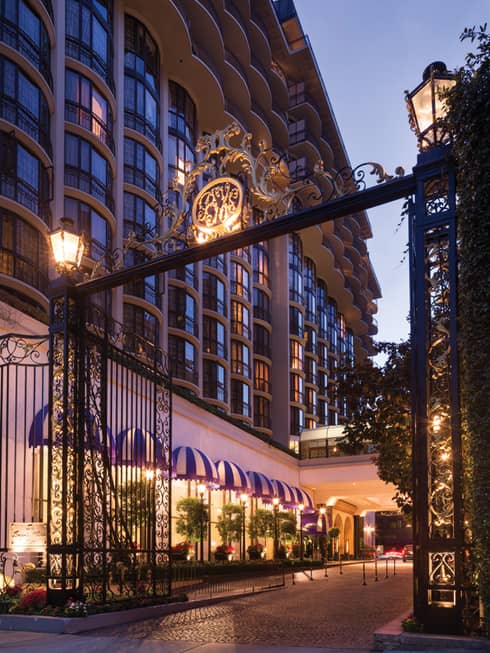 Decorative gold, black wrought-iron gate at Beverly Wilshire, <span style='font-size: .8em;'>a Four Seasons Hotel</span> entrance at sunset