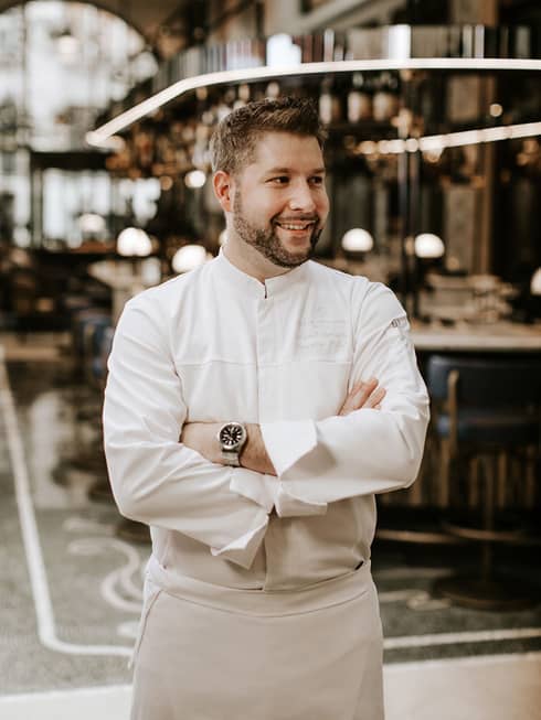 Executive Chef �rp�d Gy?rffy dressed in white chef's uniform smiling with arms crossed